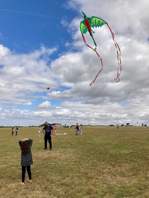 Man and child looking at kite in sky